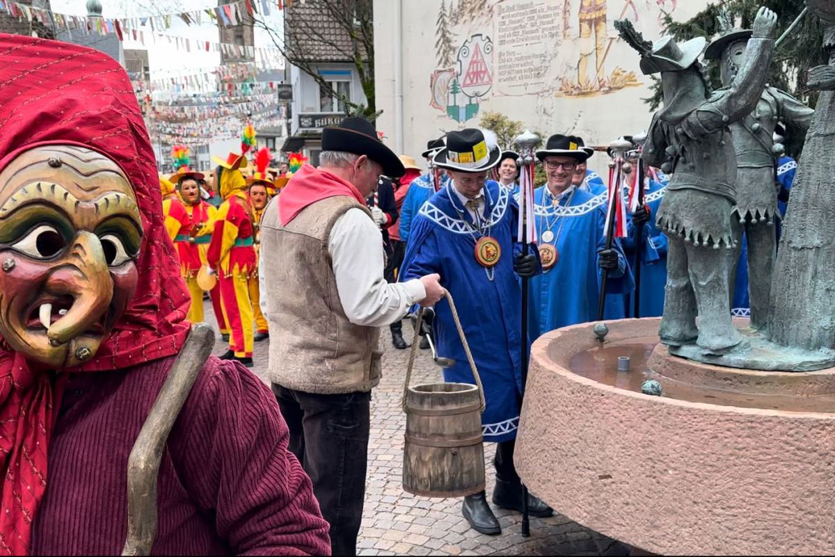 Die Narrenräte schöpfen das Taufwasser.